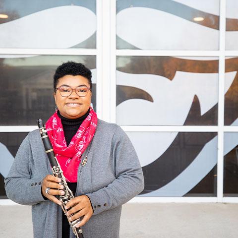 Music student stands with her clarinet 